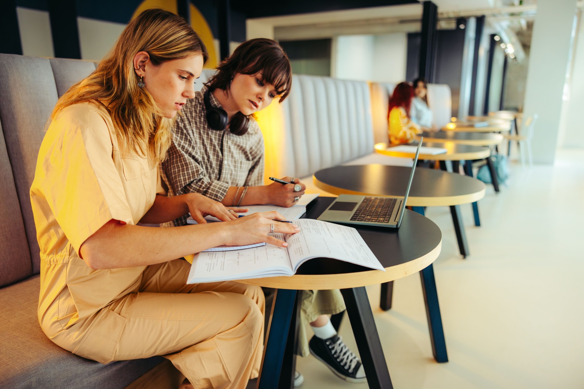 Students engaged in exam preparation at a modern workspace, discussing notes and collaborating effectively for academic success and knowledge sharing